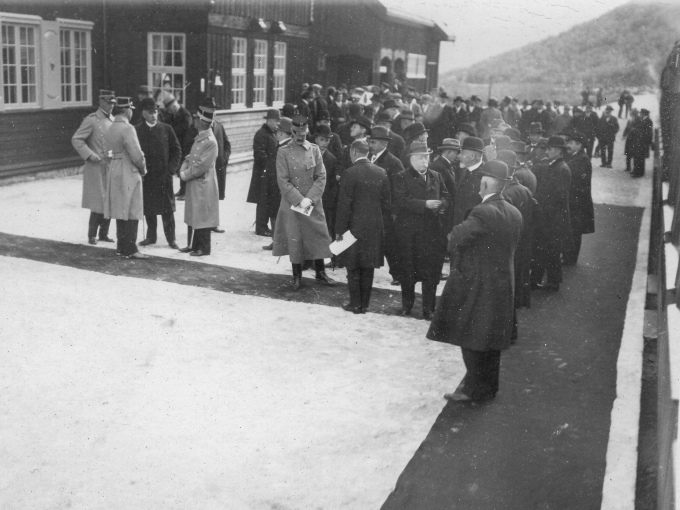 Kong Haakon og Kronprins Olav var begge til stede ved åpningen i 1921. Kronprins Olav står bak Kong Haakon, i sivilt antrekk med den klassiske engelske bowlerhatten, mens Kongen er i generalsuniform. Foto: Norsk Jernbanemuseum